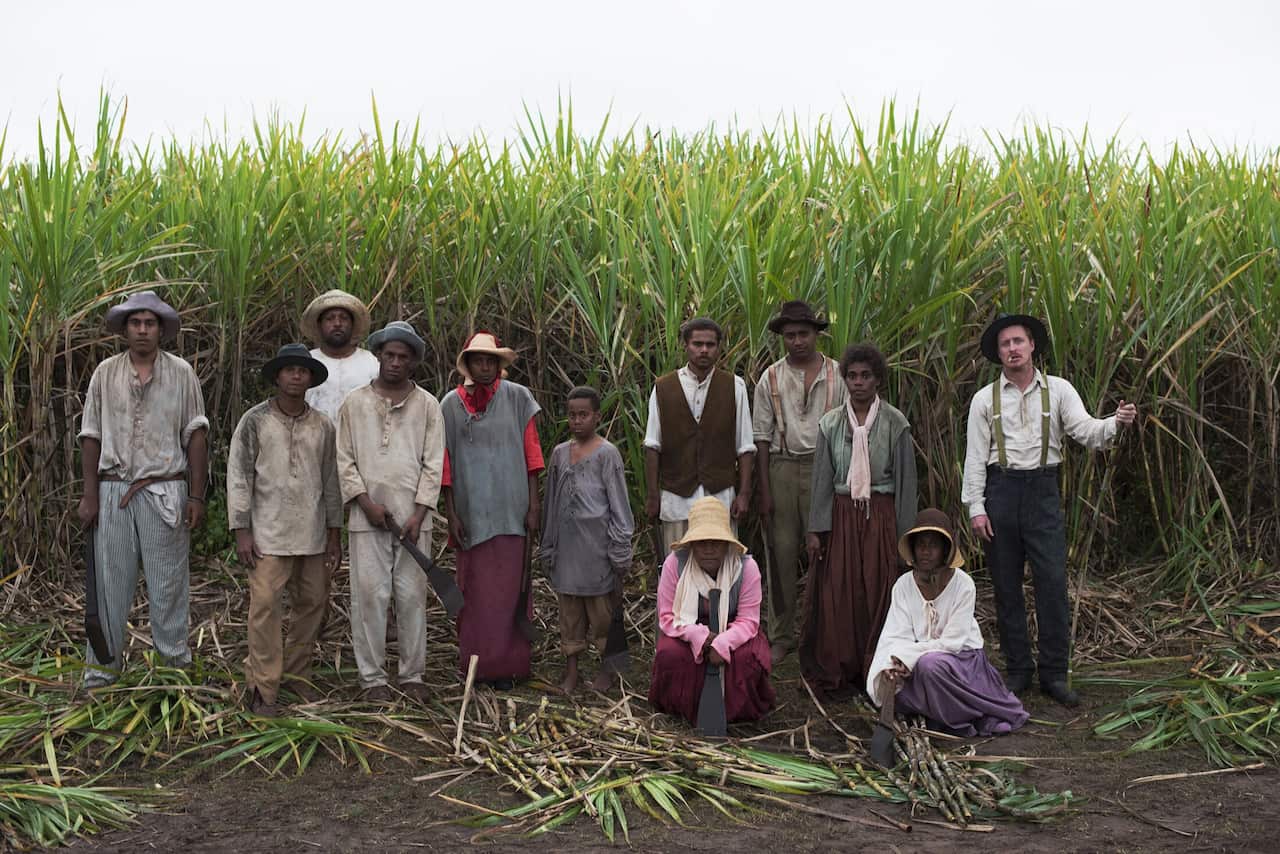 Cast of the film Blackbird in costume posing before a cane field