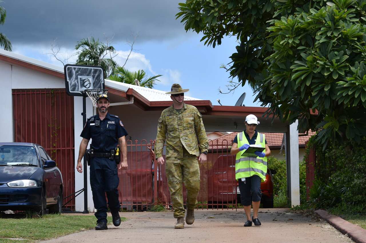 A Public Health environmental health officer, NT Police officer and an Australian Defence Force member check in on those self isolating.