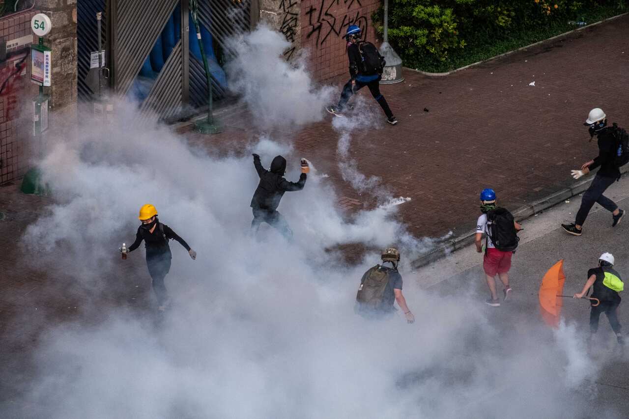Riot police officers fire teargas during clashes with protestors in the Wong Tai Sin District district of Hong Kong, on Monday, Aug. 5, 2019. A top Chinese official overseeing Hong Kong affairs said on Wednesday that the city was experiencing its worst cr