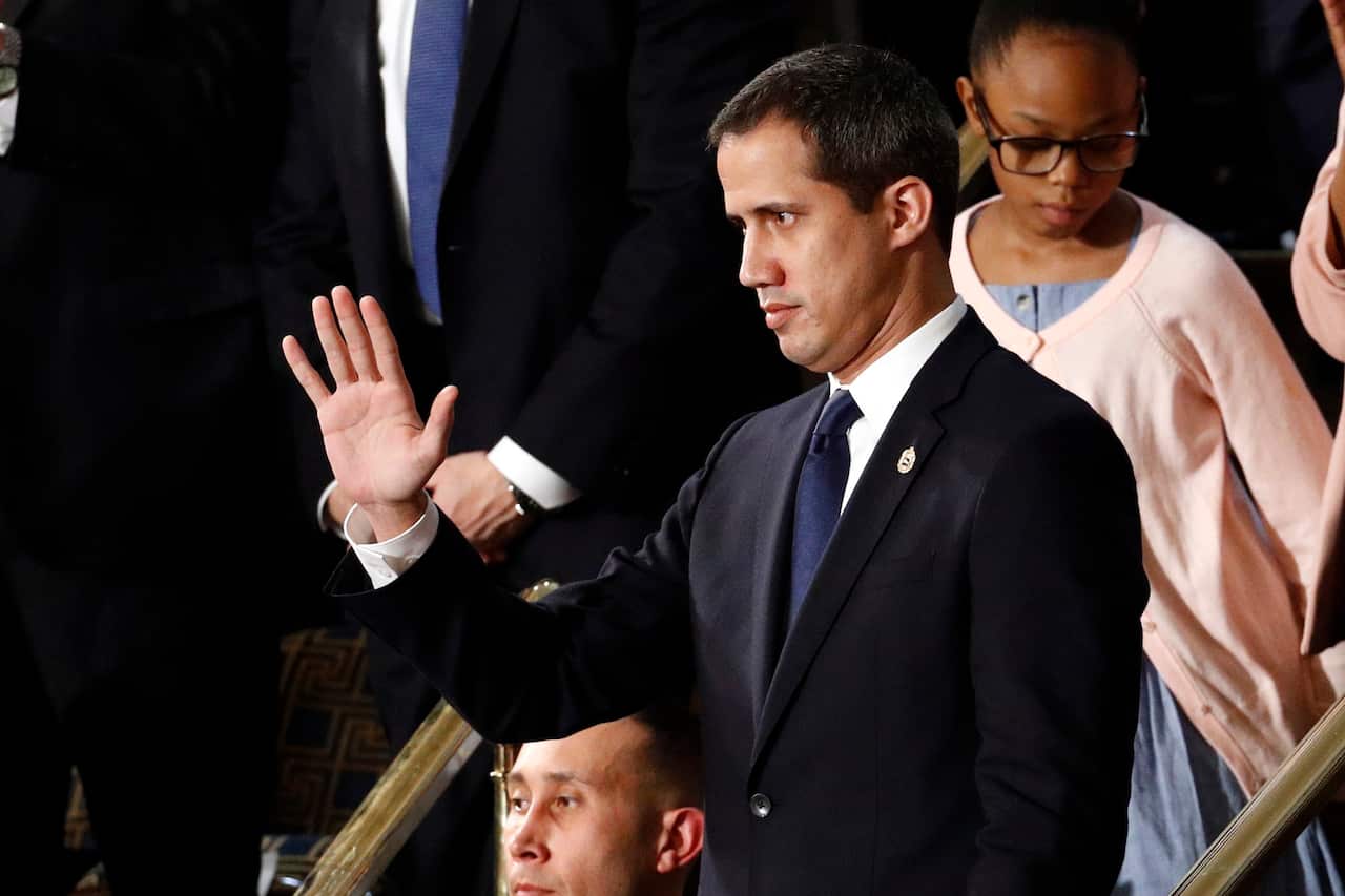Venezuelan opposition leader Juan Guaido waves as President Trump delivers his State of the Union address.