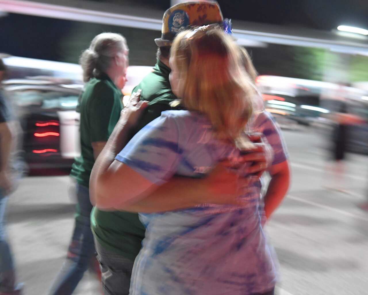 People reunite with family members in the parking lot of Gavilan College after a gunman shot into the crowd indiscriminately.