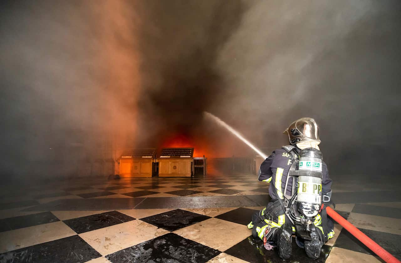 A Paris firefighter beats back flames inside the Notre-Dame Cathedral. 