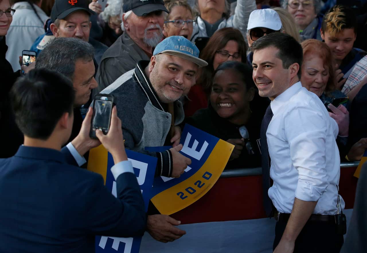 Democratic presidential candidate and former South Bend Mayor Pete Buttigieg poses for photos with supporters during a town hall rally in Sacramento, Californa.