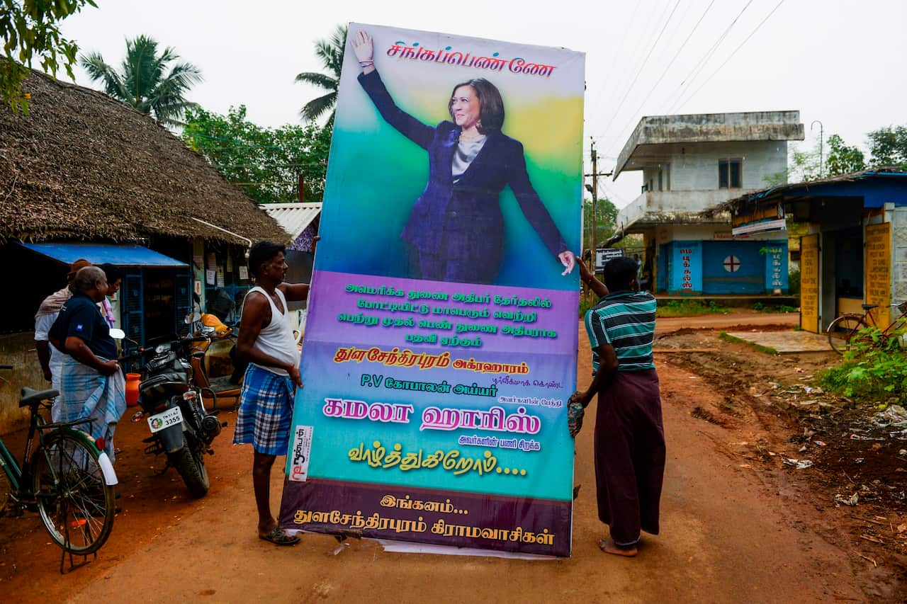 Residents prepare to put up a hoarding with a photo of US Vice President-elect Kamala Harris at her ancestral village of Thulasendrapuram.