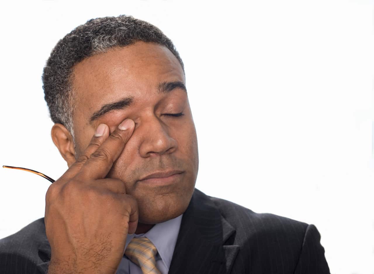 Businessman rubbing his eye