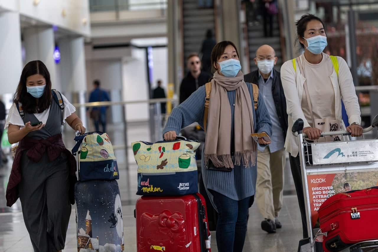 Travellers wear masks in the arrival hall of the Hong Kong International Airport.