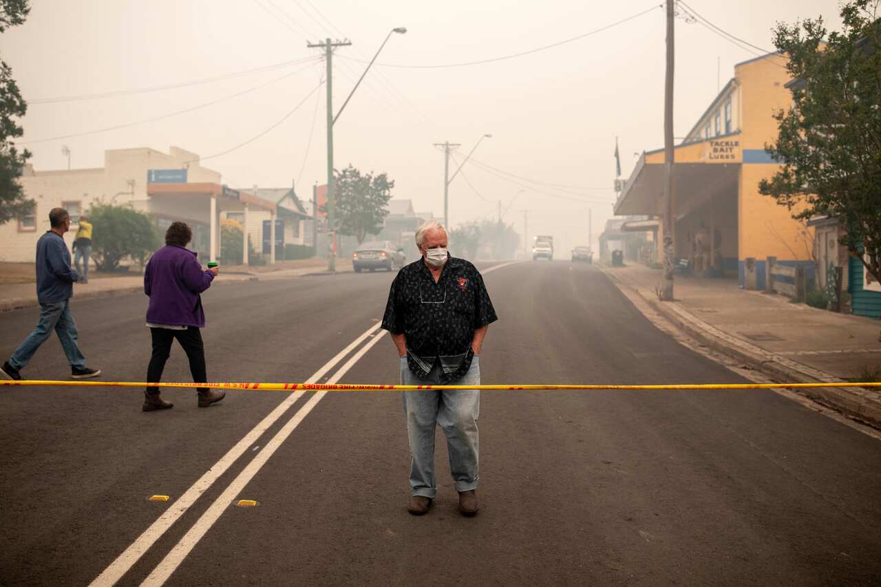 A Cobargo resident looks at destroyed buildings in Cobargo, NSW, Wednesday, January 1, 2020. Several bushfire-ravaged communities in NSW have greeted the new year under immediate threat. (AAP Image/Sean Davey) NO ARCHIVING