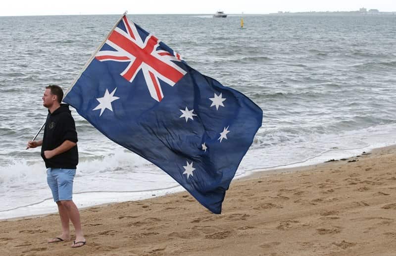 A supporter of the United Patriots Front holds an Australian flag on St Kilda beach in Melbourne,on 5/1/19. 