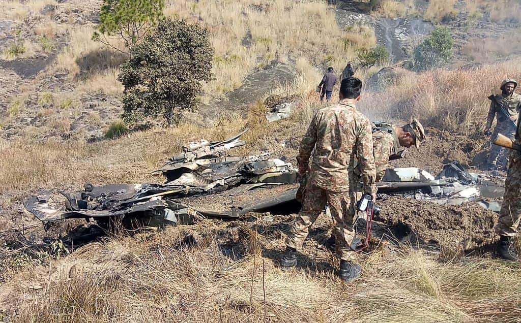 Pakistani soldiers stand next to what Pakistan says is the wreckage of an Indian fighter jet shot down in Pakistan controled Kashmir