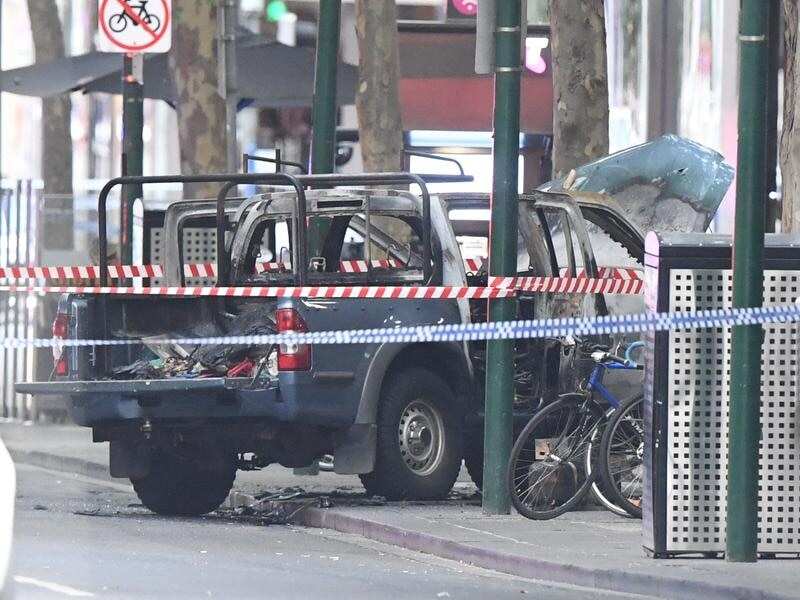 A burnt out vehicle is seen on Bourke Street in Melbourne.