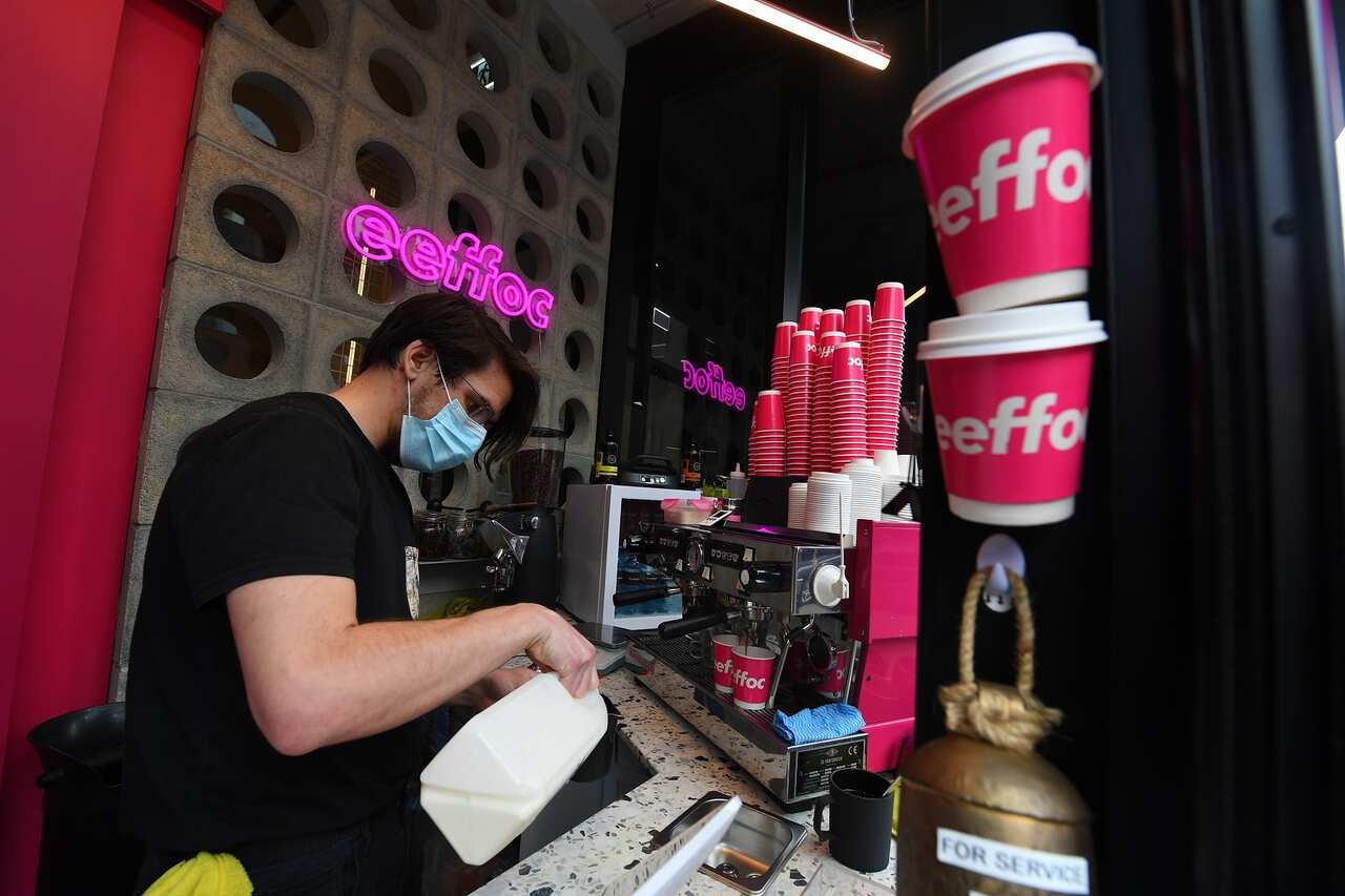 Barista Alex Pallas is seen making a coffee at Eeffoc Cafe in Prahran, Melbourne.