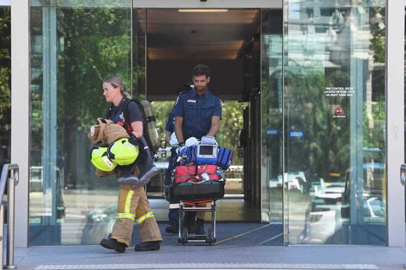 Emergency service personal exiting the building where the Korean consulate is located in Melbourne.