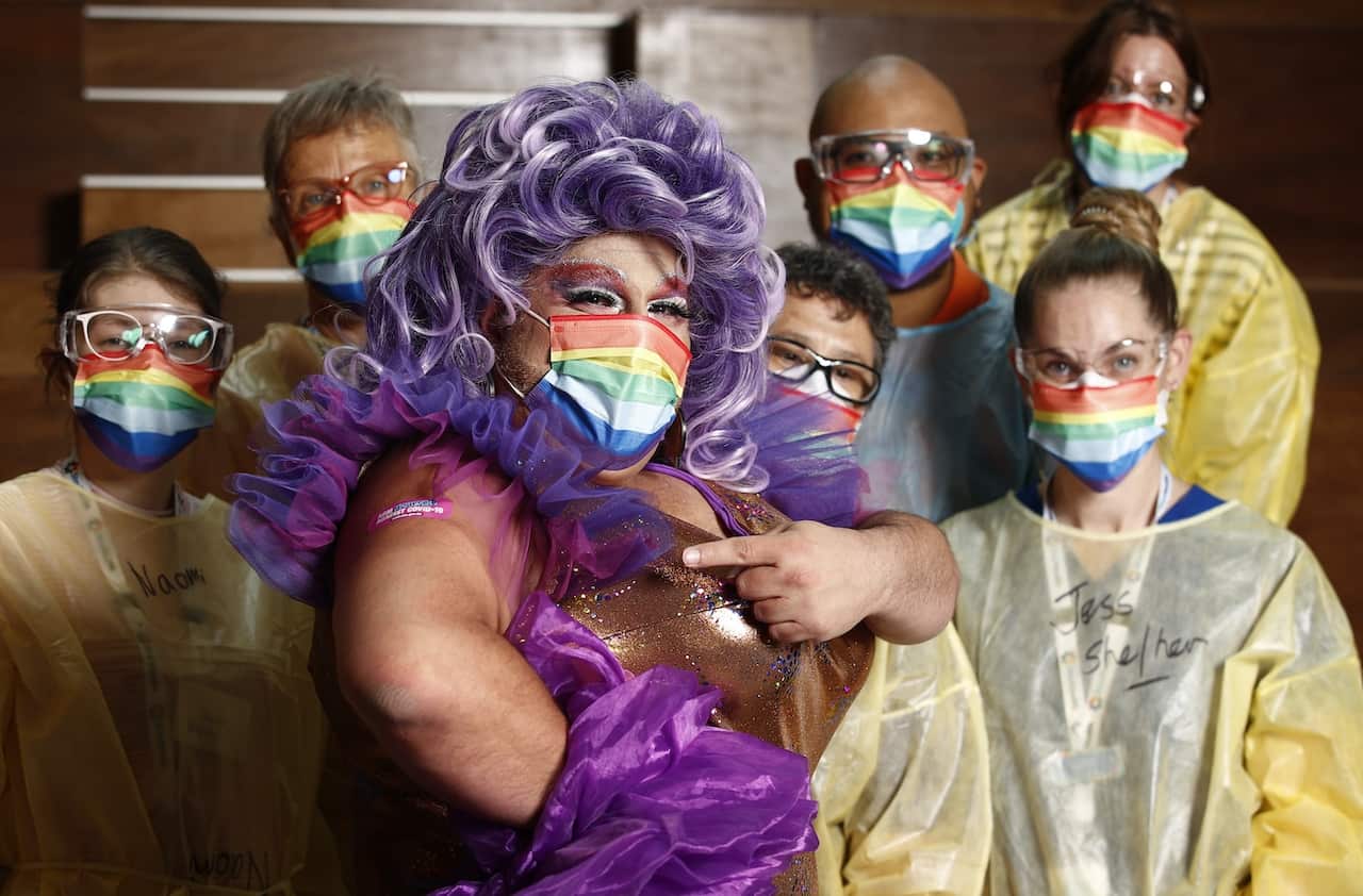 Frock Hudson (centre) poses for a photograph with health staff at the Victorian Pride Centre in Melbourne, Monday, October 18, 2021