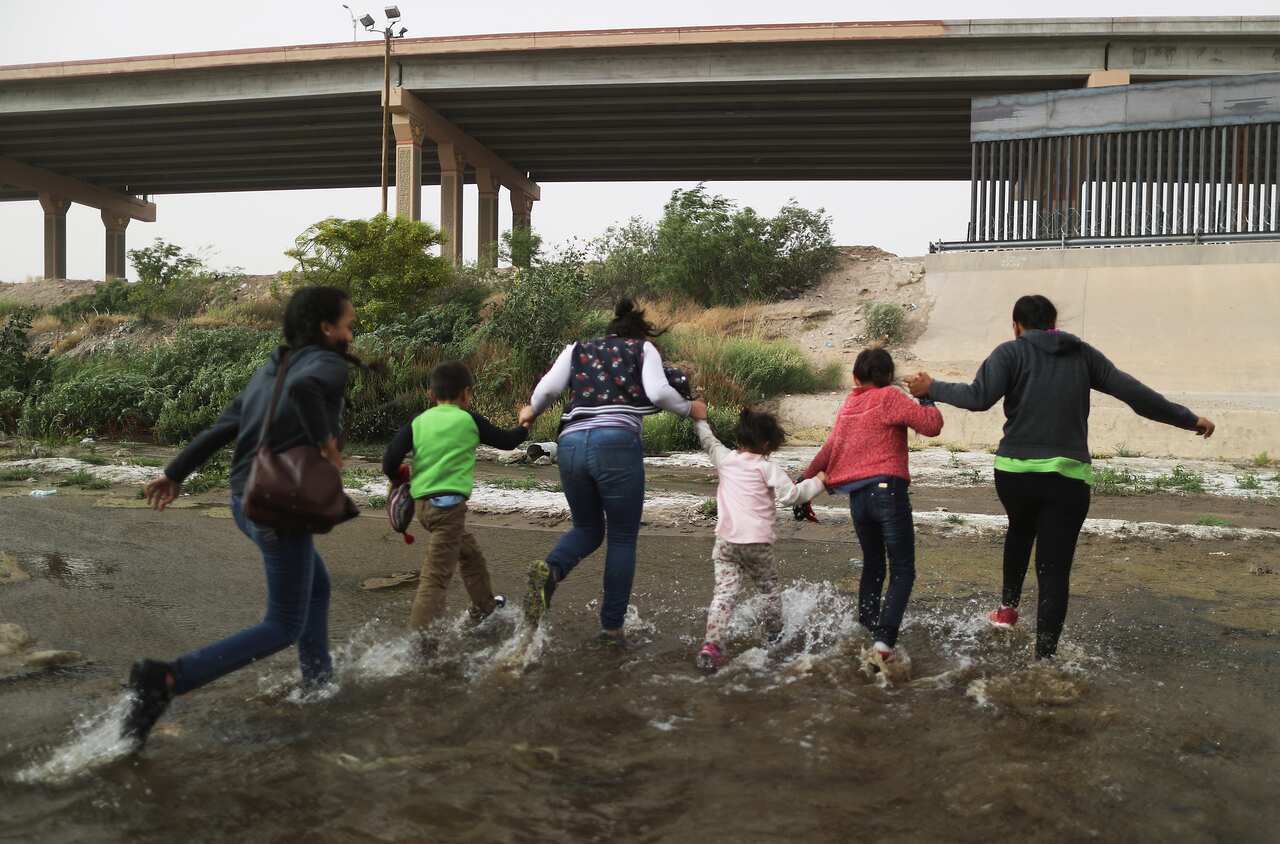 Migrants cross the border between the US and Mexico at the Rio Grande river, as they enter El Paso, Texas.