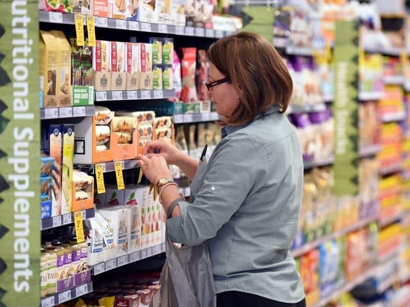 An employee puts price tags on selves at a Woolworths supermarket