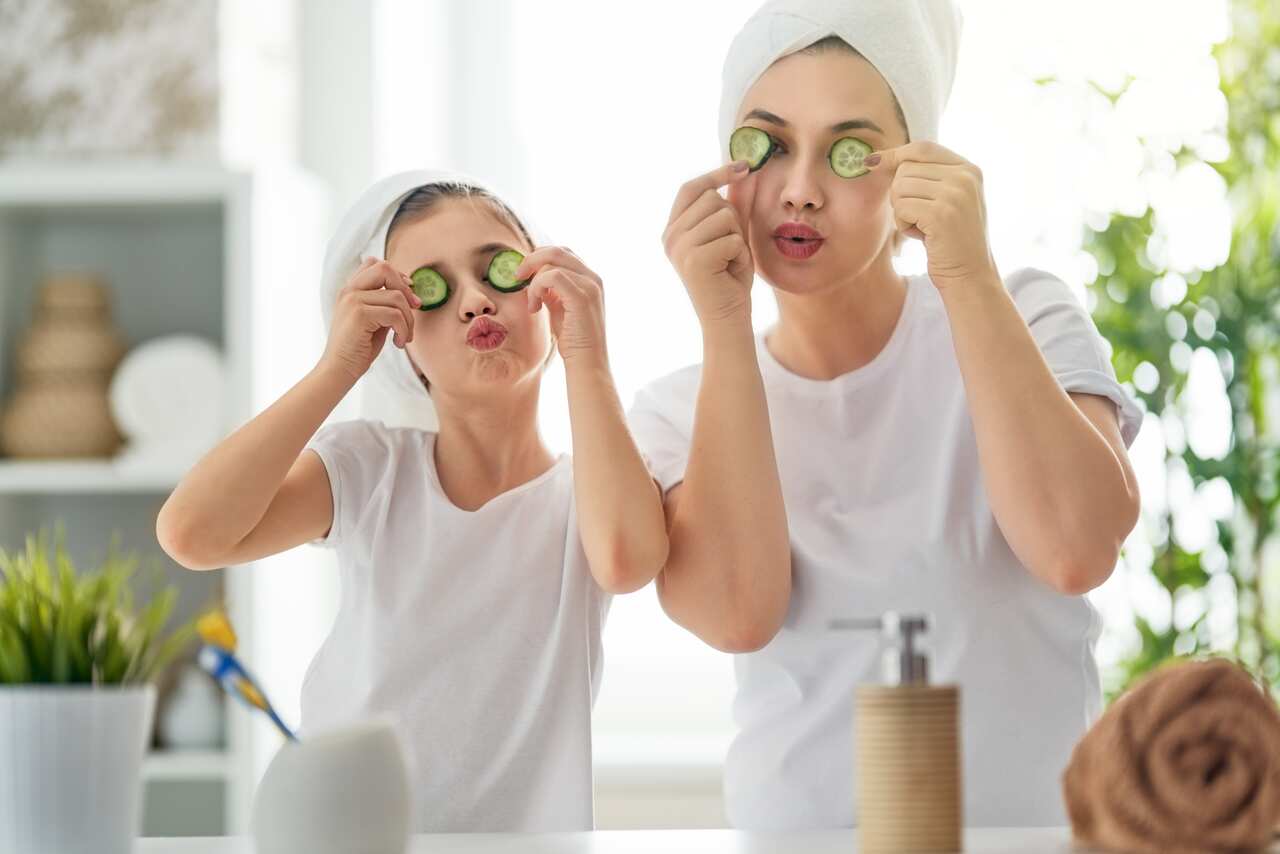 Happy family! Mother and daughter child girl are caring for skin in the bathroom.