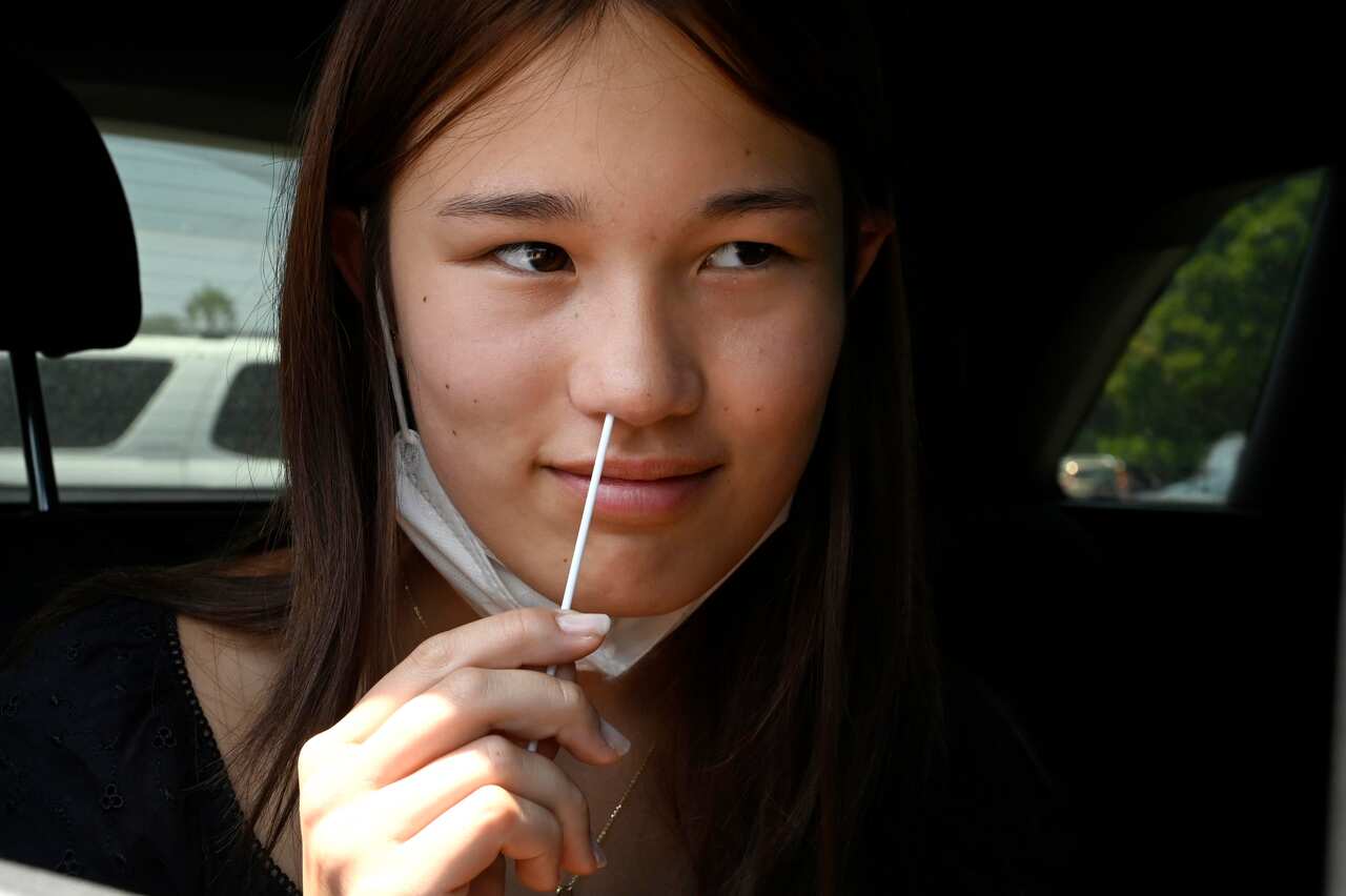 High school student Sophia Brach swabs herself for a rapid COVID-19 test