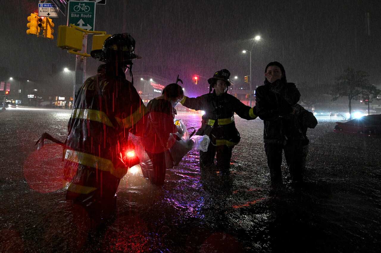 Members of the FDNY rescue a woman from her car stalled due to flash flooding after remnants of Hurricane Ida in the New York City, 1 September, 2021. 
