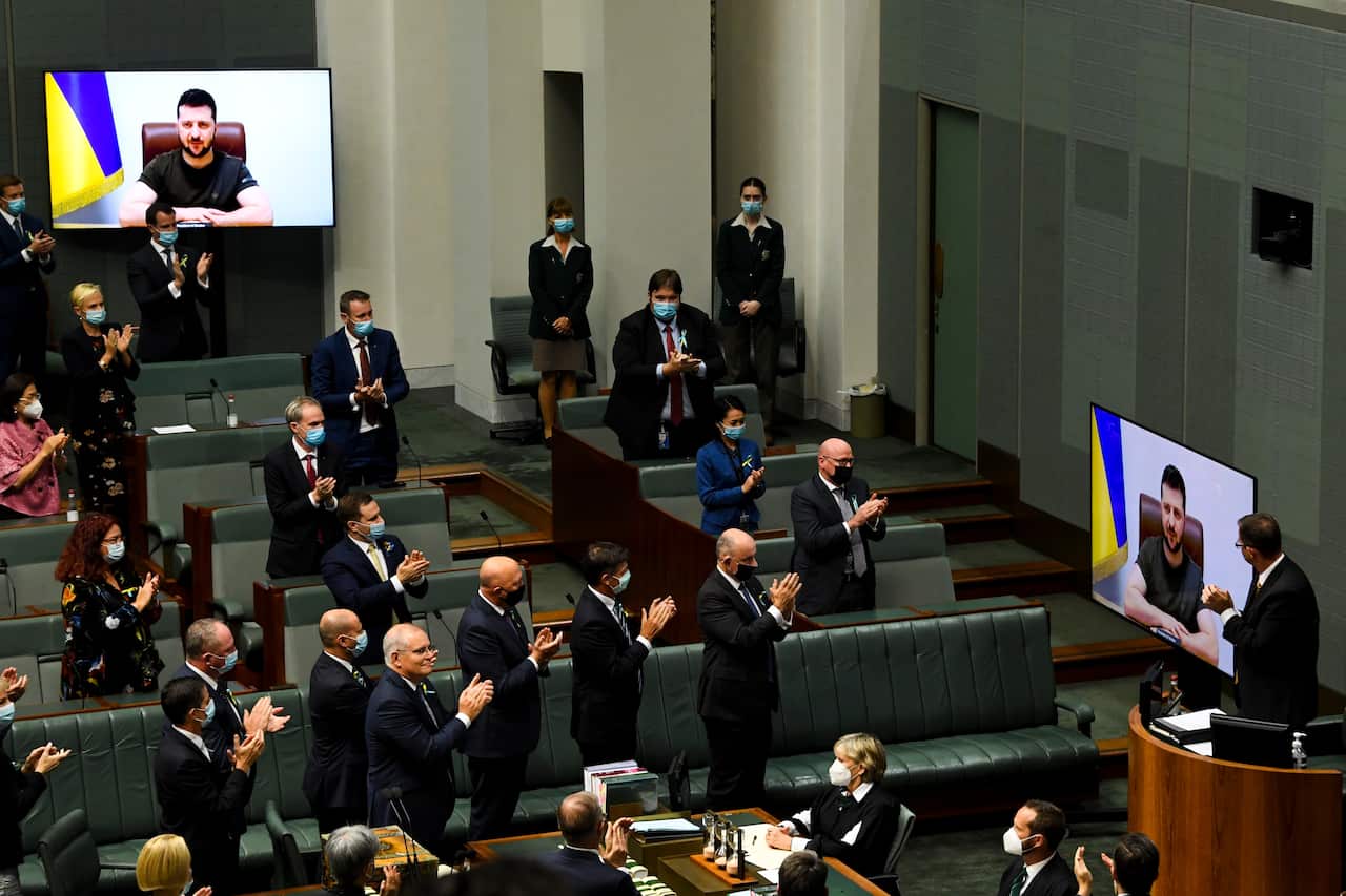 Australian members of Parliament applaud as Ukrainian President Volodymyr Zelenskyy addresses the House of Representatives via a video link at Parliament House in Canberra, Thursday, March 31, 2022. (AAP Image/Lukas Coch) NO ARCHIVING