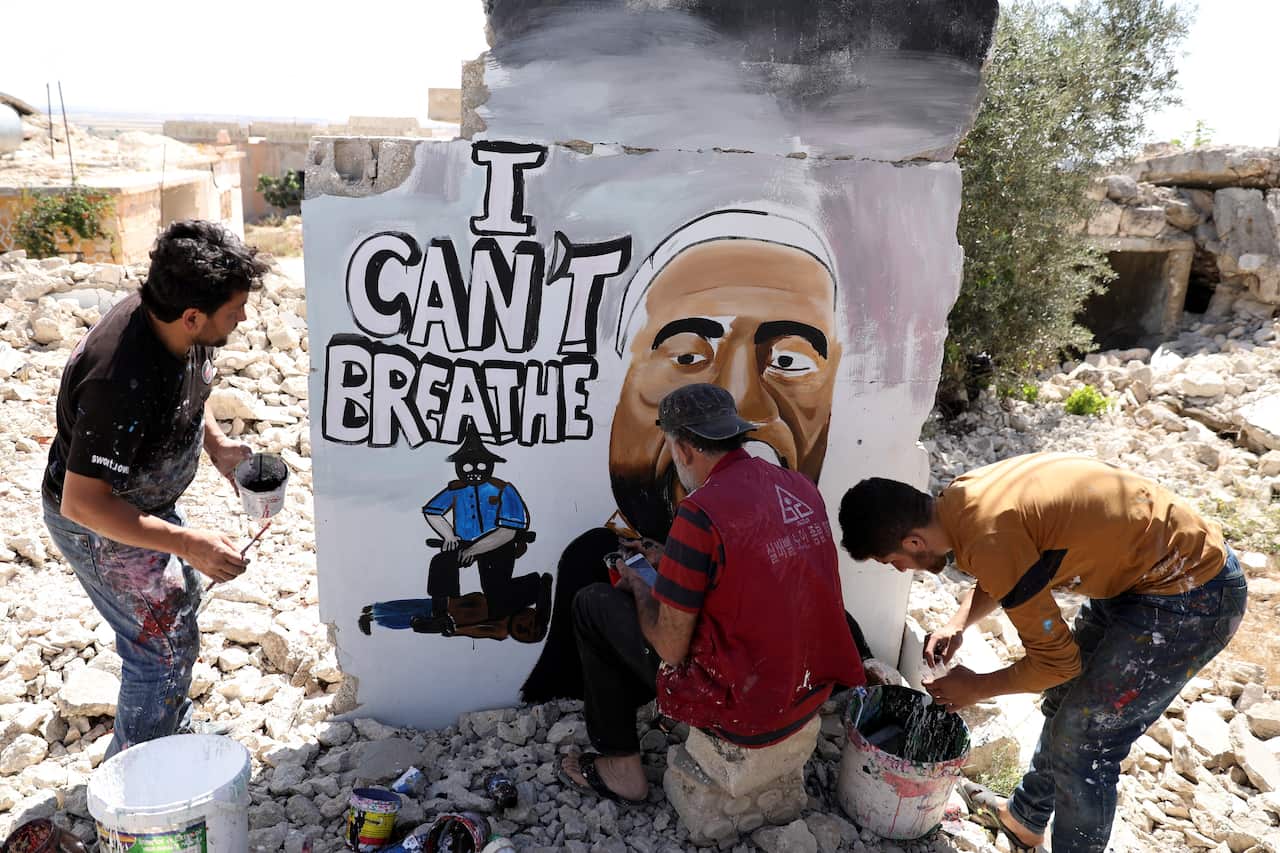 Syrians spray graffiti to honour the killed US man George Floyd on the wall of a house destroyed by war, Idlib, Syria.