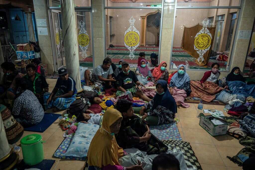 Evacuees take shelter at the local mosque of Sumber Wuluh village, in Lumajang, on December 5, 2021, after the eruption of Semeru volcano. 
