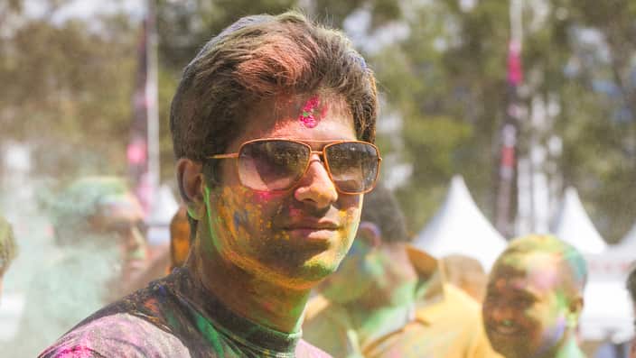 A festival goer covered in powdered colours at the annual Holi Mahotsav Festival in Darling Harbour, Sydney