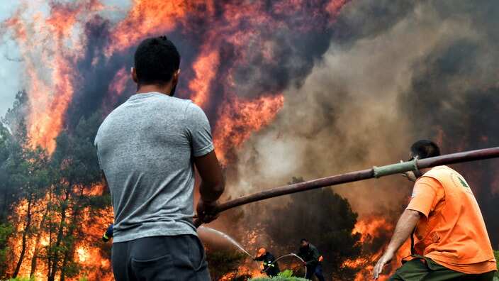 Firefighters and volunteers try to extinguish a wildfire raging in Verori, near Loutraki city, Peloponnese, southern Greece, 24 July 2018.