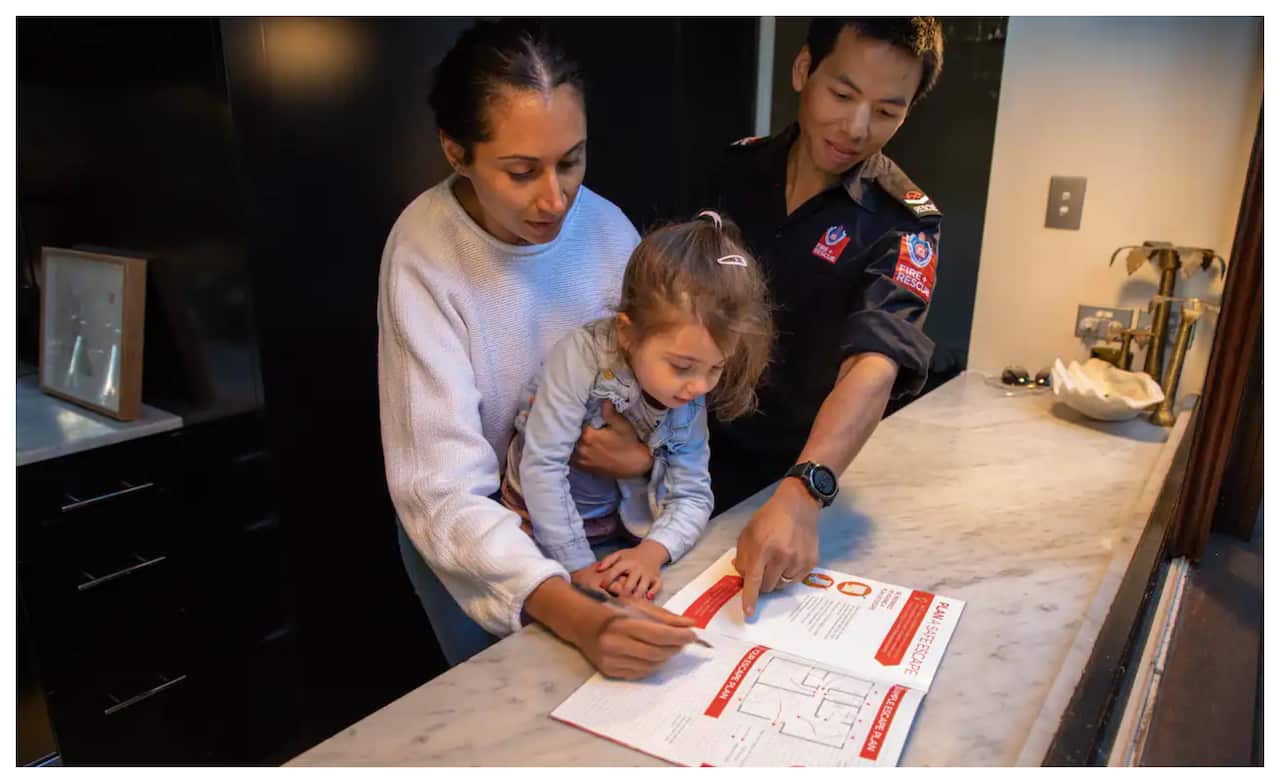 เจ้าหน้าที่ดับเพลิงพูดคุยกับครอบครัวเรื่องการเตรียมแผนเมื่อเกิดเหตุไฟไหม้