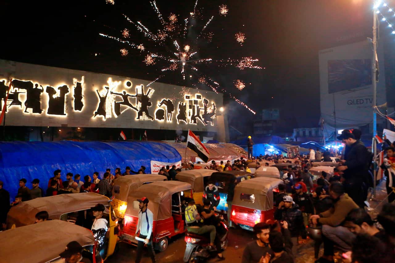 Iraqi soccer fans celebrate Iraq's win over Qatar in the 24th Arabian Gulf Cup soccer championship opening match during ongoing anti-government protests