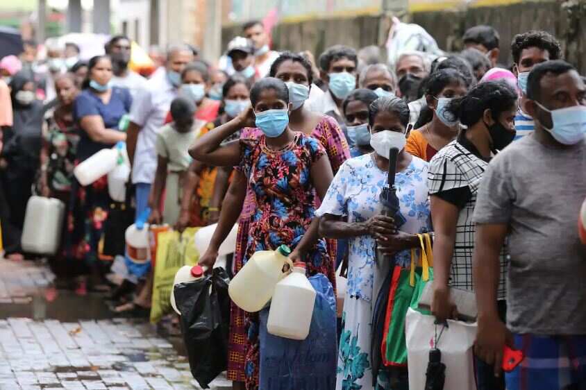 People wait to buy kerosene at a gas station amid a fuel shortage in Colombo, Sri Lanka, 11 April 2022.