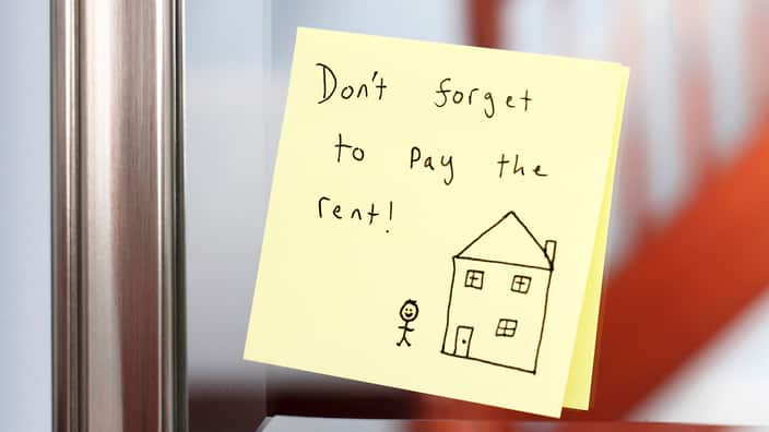 Post-it note with rent reminder on mirror