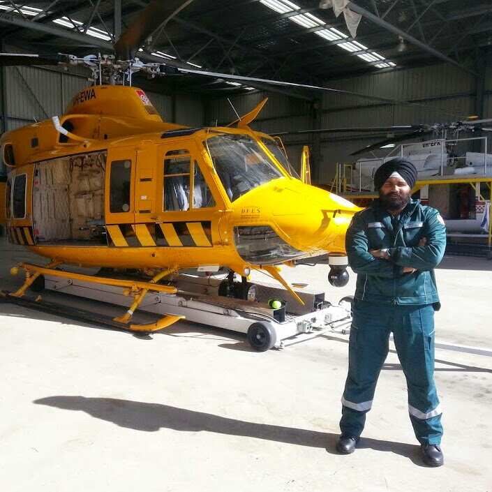 Communications Officer Gagandeep S Padda standing by a helicopter ambulance