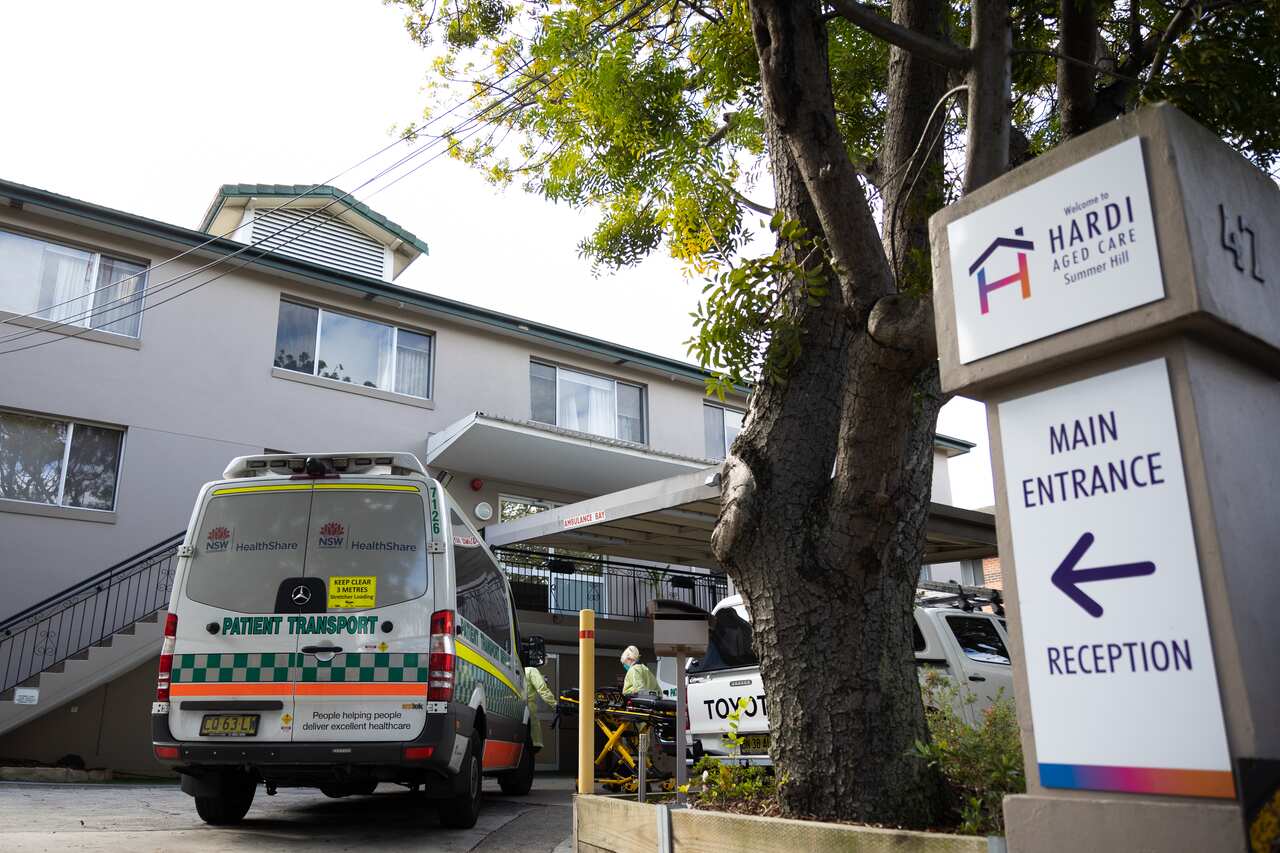  Ambulance attendants wearing full protective clothing prepare a gurney to transport residents to hospital at the Wyoming Nursing Home on August 2, 2021 in Sydney, Australia.