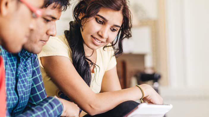 Young Indian friends using digital tablet