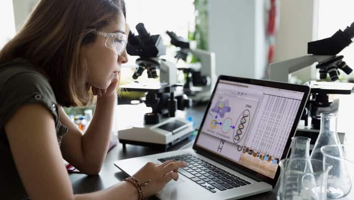 College student using laptop in science laboratory