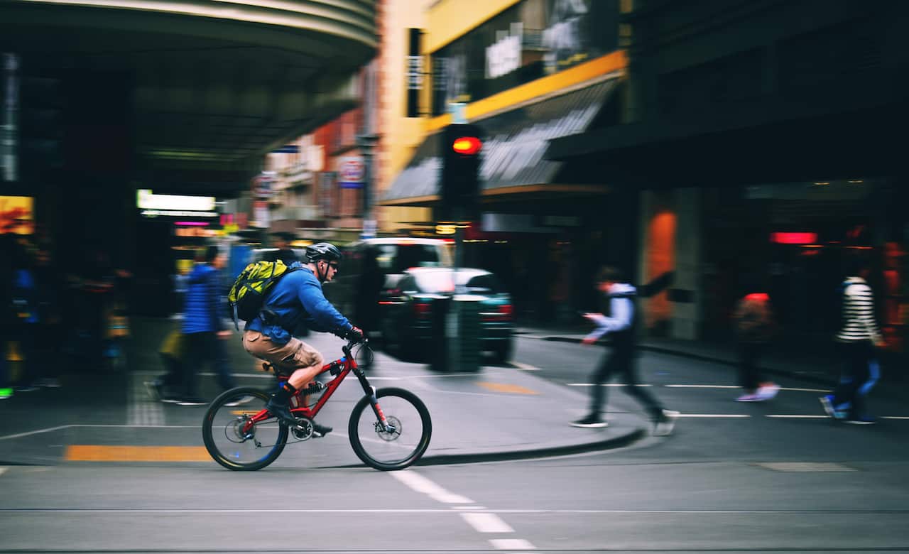Man Riding Bicycle On Road In City