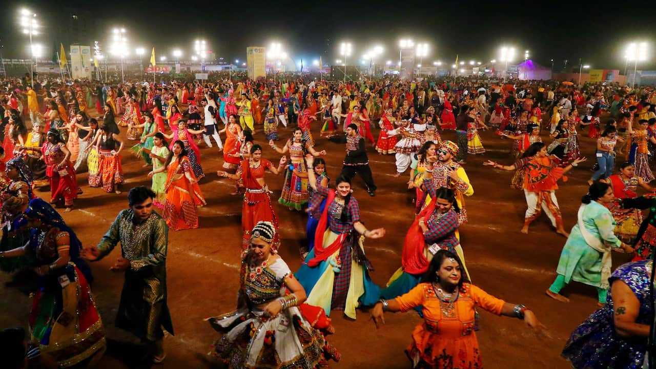 Indian men and women perform Garba Dandiya dance during the Navratri festival 