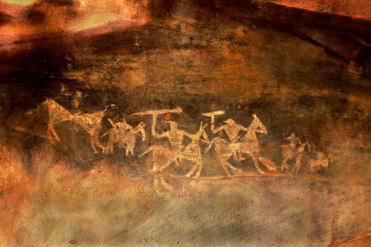 Sketches of warriors on horseback with swords in their hands drawn by primitive people at Bhimbetka Caves near Bhopal, Madhya Pradesh, India.