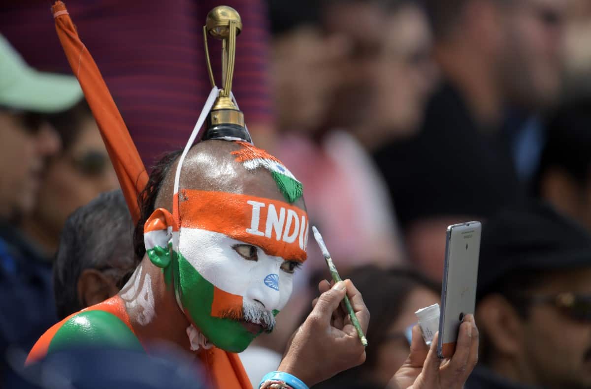 Indian supporter Sudhir Gautam adjusts his make up during the 2019 Cricket World Cup group stage match between England and India