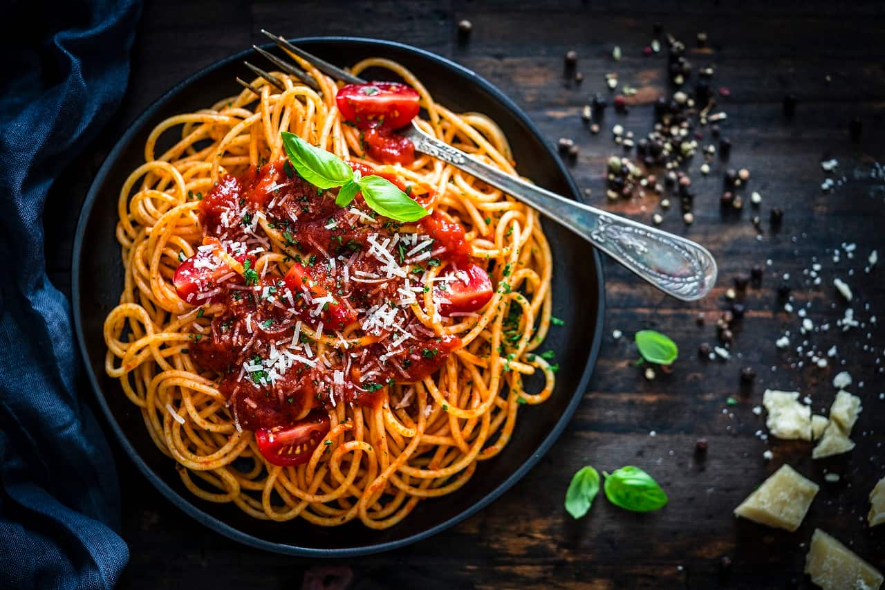 Spaghetti with tomato sauce shot on rustic wooden table