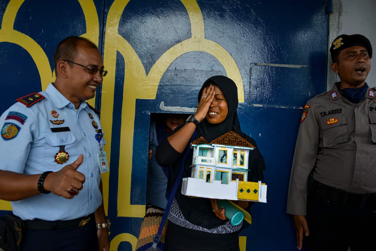 A woman (C) reacts after she was released from prison, due to concerns of the spread of the COVID-19 coronavirus, in Lhoknga near Banda Aceh on April 6, 2020.