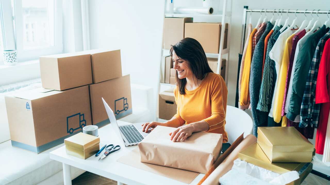 A woman is preparing a package for delivery to clients 