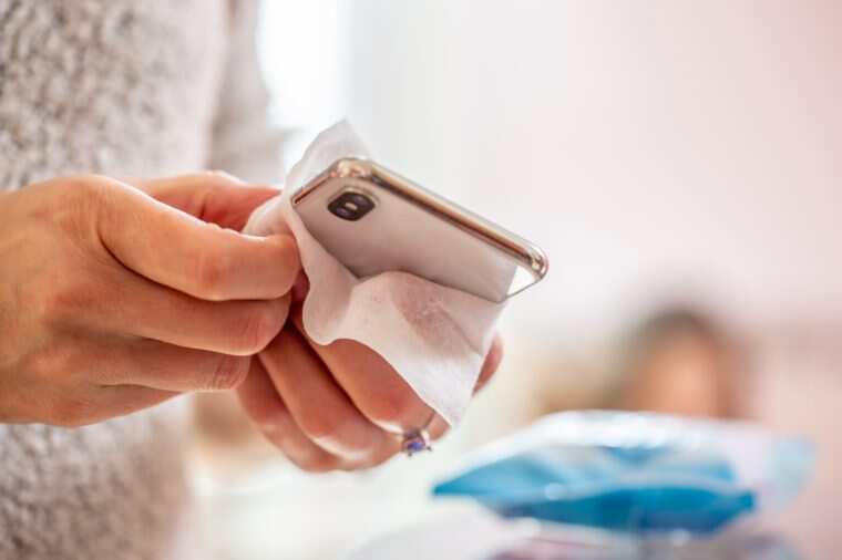 Cleaning a cell phone with a disposable Antibacterial Wipe during Coronavirus emergency