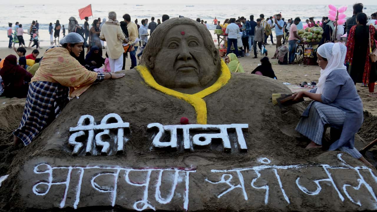 An artist (R) works on a sand sculpture to pay tribute to late Bollywood playback singer Lata Mangeshkar at Juhu Beach in Mumbai on February 7, 2022. 