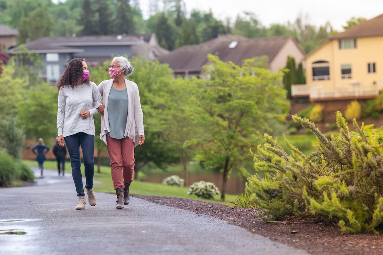 Senior woman and her adult daughter enjoying the outdoors together during Coronavirus