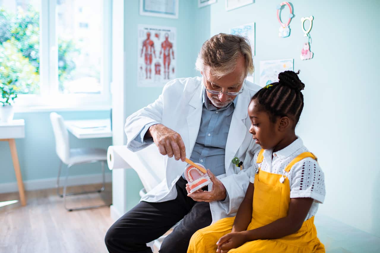 Little girl learning how to brush her teeth