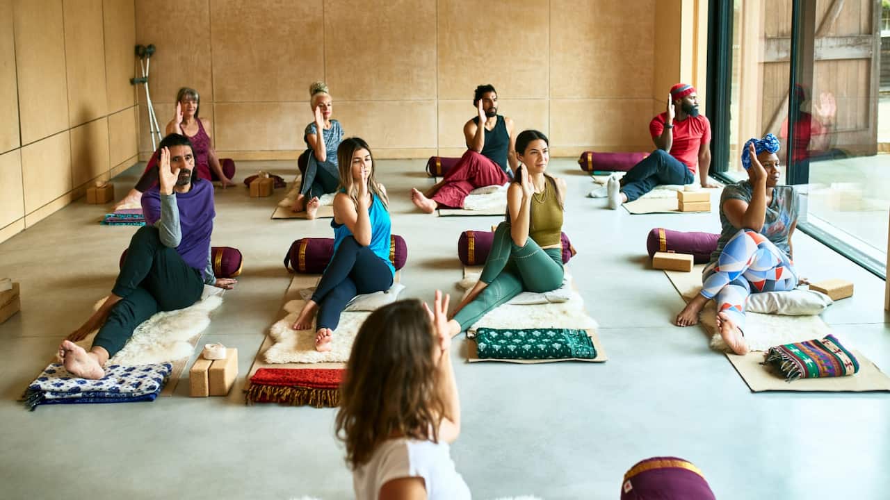 Yoga instructor at front of class guiding students