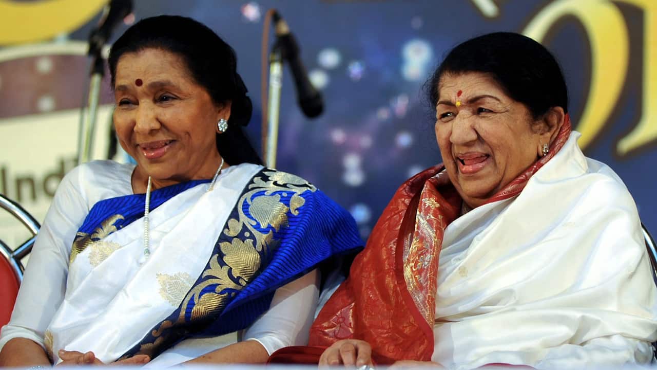 Indian Hindi and Marathi language Bollywood playback singer Lata Mangeshkar (R) sits alongside her sister Asha Bhosle also a playback singer during the Pandit Hridaynath Mangeshkar’ Awards in Mumbai late March 31, 2013. 
