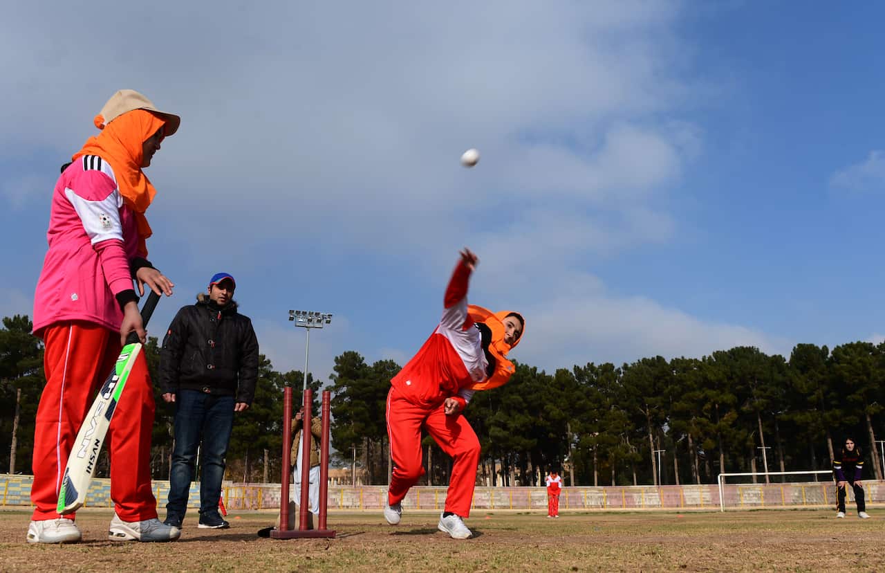Afghan women play cricket at the grounds of the stadium in Herat on December 9, 2015.