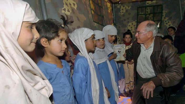 Former Australian Prime Minister John Howard talks with schoolchildren at a makeshift school in an Australian relief camp in Pakistan 2005.